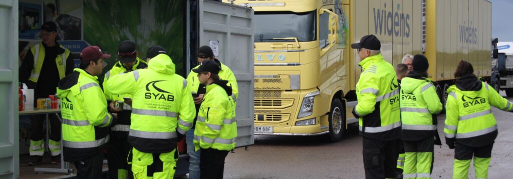 Elever i varselkläder vid lastbil