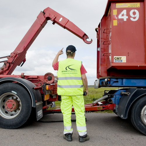 Förare i varselkläder vid en lastväxlarbil